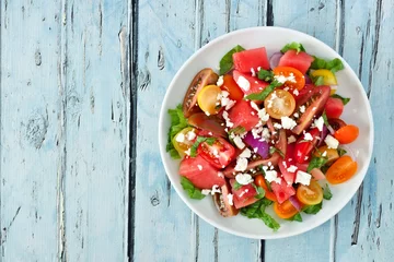 Poster Watermelon and mixed tomato salad with feta cheese, above view on rustic blue wood © Jenifoto
