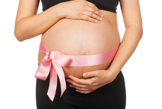 Pregnant woman with pink ribbon around her belly