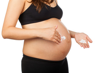 pregnant woman massaging her belly with ointment against stretch - obrazy, fototapety, plakaty