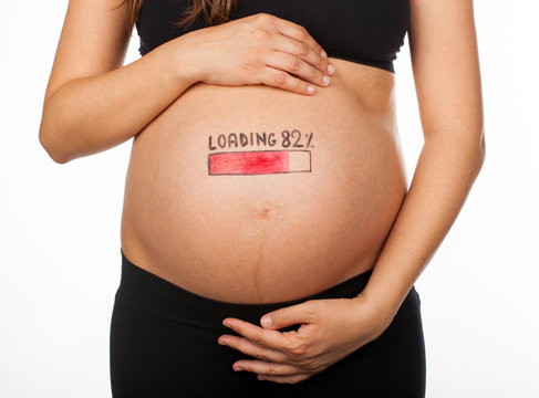 Pregnant woman with loading concept painted on her belly.