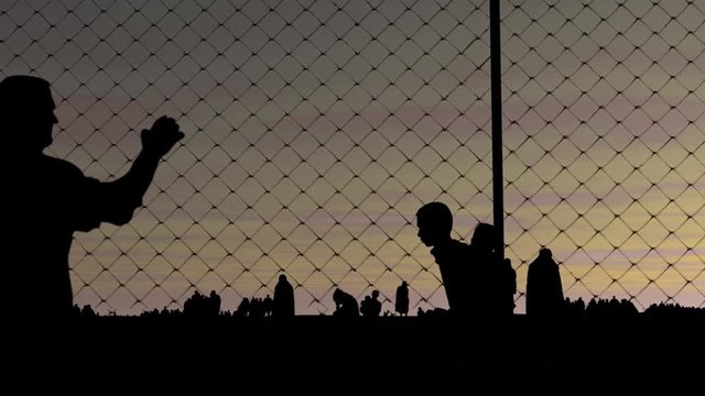 Refugees. Men and women and a fence. The concept of refugees