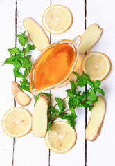 ginger honey lemon mint on a white wooden background ingredient
