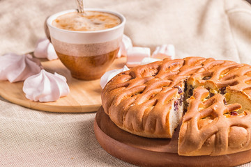 sweet buns, meringues and coffee cup on a wooden board