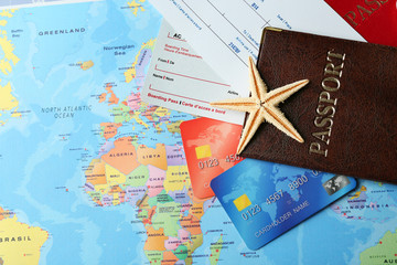 Credit cards with passports and tickets for vacations on the world map background