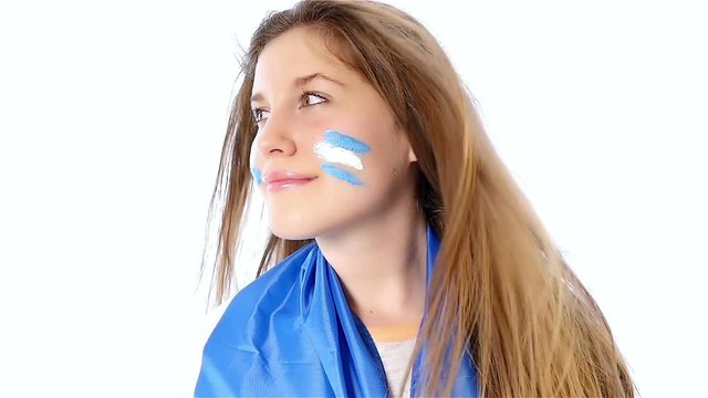 Girl with Argentinian flag on her face smiling, slow motion