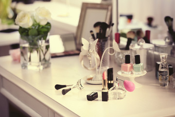 Lipstick with perfume bottle on light dressing table