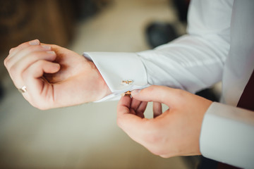 Man corrects belt, fees groom, man's hands, dressing, man buttons pants, jeans