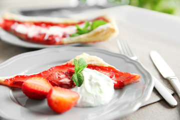 Strawberry dessert slice with cream on gray plate