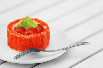 Strawberry biscuit cake in white plate on light wooden table