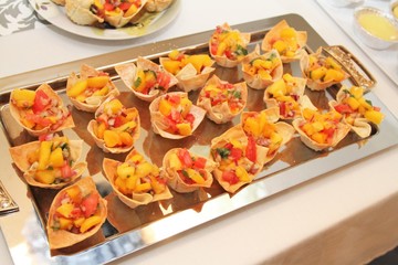 Party tray of taco shells filled with mango salsa