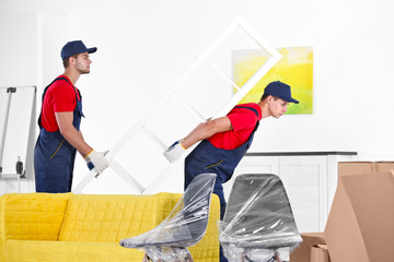 Male workers carrying furniture in new house