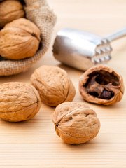 Walnuts kernels and whole walnuts on wooden background. Whole an