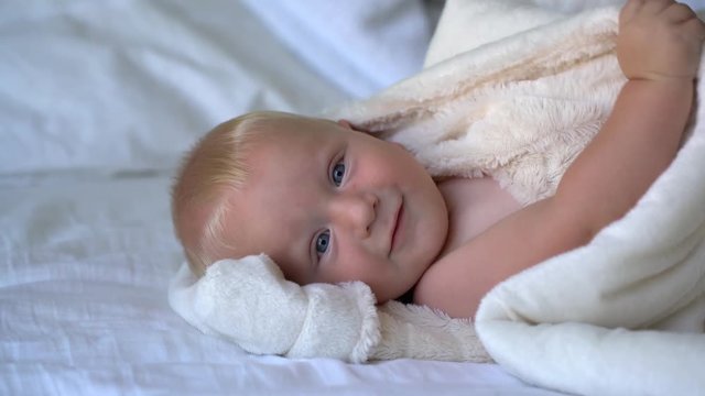 cute baby peeking out of a blanket