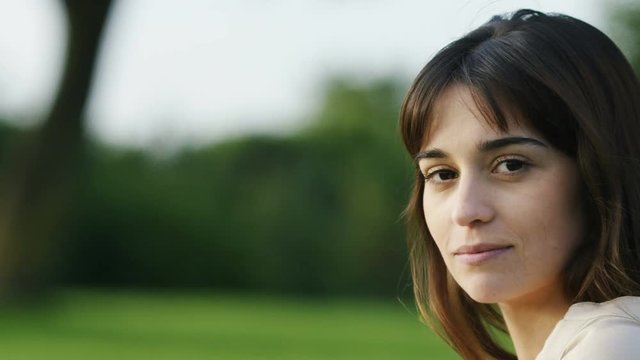 4K Portrait of an attractive woman looking to camera with a gentle smile, in slow motion