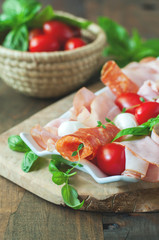 Ham, salami, antipasto, mozzarella and bocconcini soft cheese,  selective focus, toned image