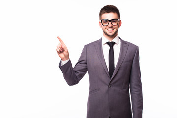 Handsome smiling businessman pointing finger away over gray background
