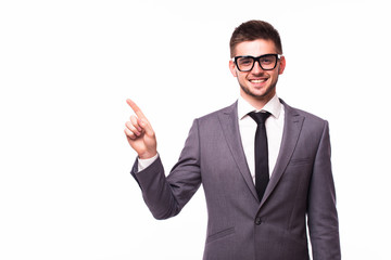 Handsome smiling businessman pointing finger away over gray background