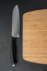Cutting board with knife on black counter