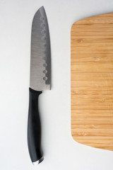 Cutting board with knife on white counter