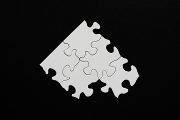 Five blank puzzle pieces on black background