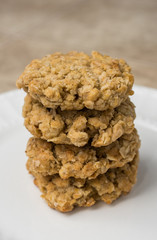 Stack of four oatmeal cookies on white plate