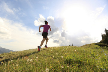 Fototapeta premium healthy young woman trail runner running on beautiful mountain peak