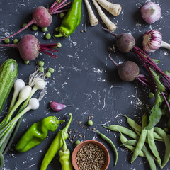 Fresh vegetables - beets, peppers, green beans, onion, garlic, zucchini on dark background. Top view