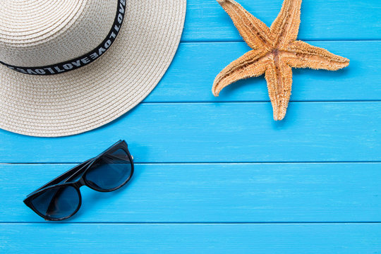 Straw hat and sunglasses on wood