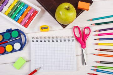 Book and school accessories on white boards, back to school concept