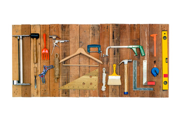 Set of tools hanging on wood board isolated on white background
