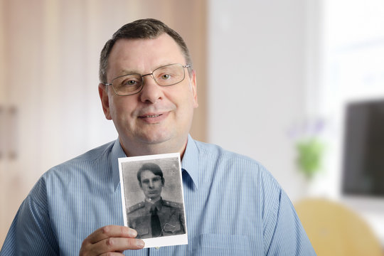 Chubby man holds old photograph