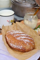 Homemade bread, milk, cream on a wooden background
