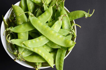 peas and green nut on black background
