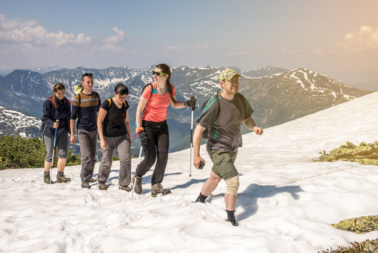 hikers go in groups through the snow