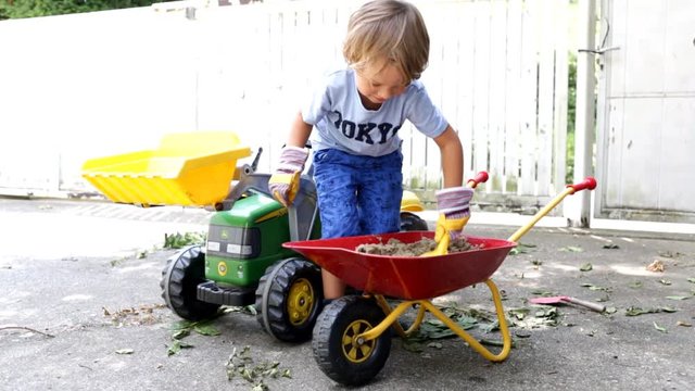 4 j&auml;hriger Junge spielt mit Sand, Wasser, Traktor, Bagger und Scheibtruhe
