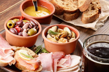 Tapas of salmon, mussels, jamon and olives with beer
