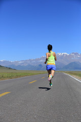 young asian woman runner running on mountain peak