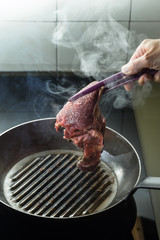 Grilling steak on grill pan. Beefsteak cooking on a kitchen. Fresh, delicious, spicy, juicy meat with copy space closeup.