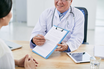 Doctor showing medical survey to his female patient