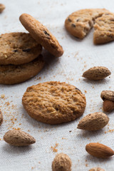 Cookies pile with chocolate chip and almond on light textile background. Delicious morning snacks for breakfast, brunch and lunch. Appetizing, healthy and fast food
