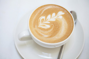 Cup of art latte or cappuccino coffee with retro filter effect