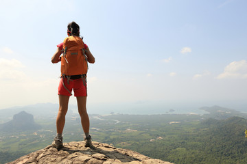 Fototapeta na wymiar successful woman hiker enjoy the view on mountain top rock