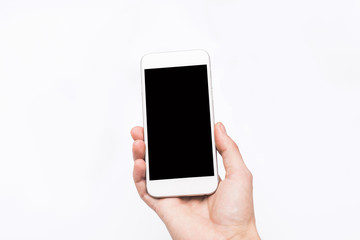 Hand holding smart mobile phone on wooden table and light blurre