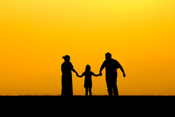 Fototapeta na wymiar Silhouette of a family walking in sunset