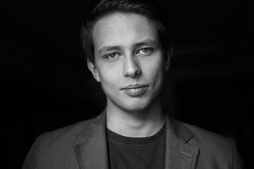 Handsome young man on dark background. Black and white photo