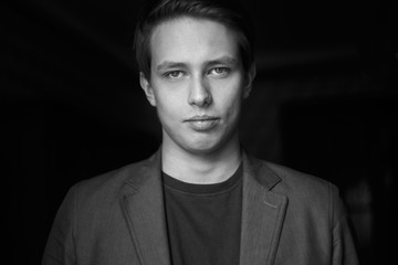 young man close up portrait, on black background