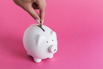 Inserting a coin into a piggy bank