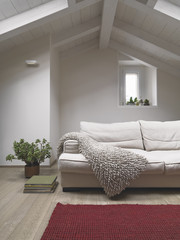 foreground of fabric sofa in the  modern living room in the attic with red carpet and wooden floor