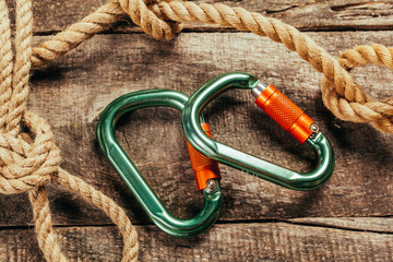 Climbing rope and carabiner on wooden board