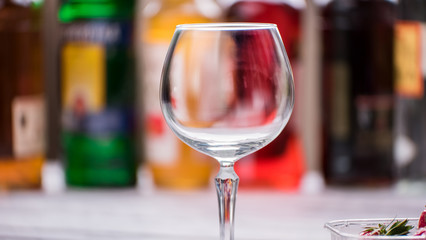 Empty and clean wineglass. Glass on blurred background. Welcome to the bar. Drink anything you want.
